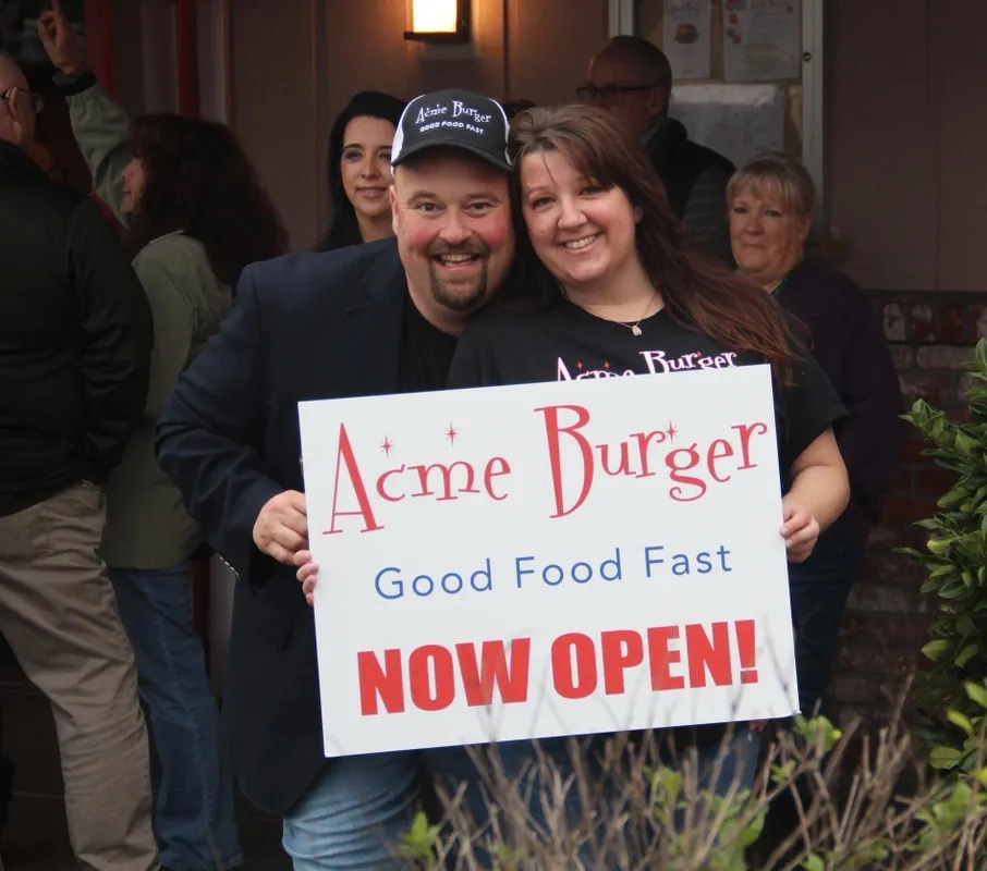 a group of people holding a sign posing for the camera
